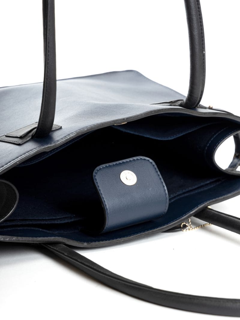 Interior view of navy blue and black plant leather tote bag showing compartments and inner pockets with magnetic closure