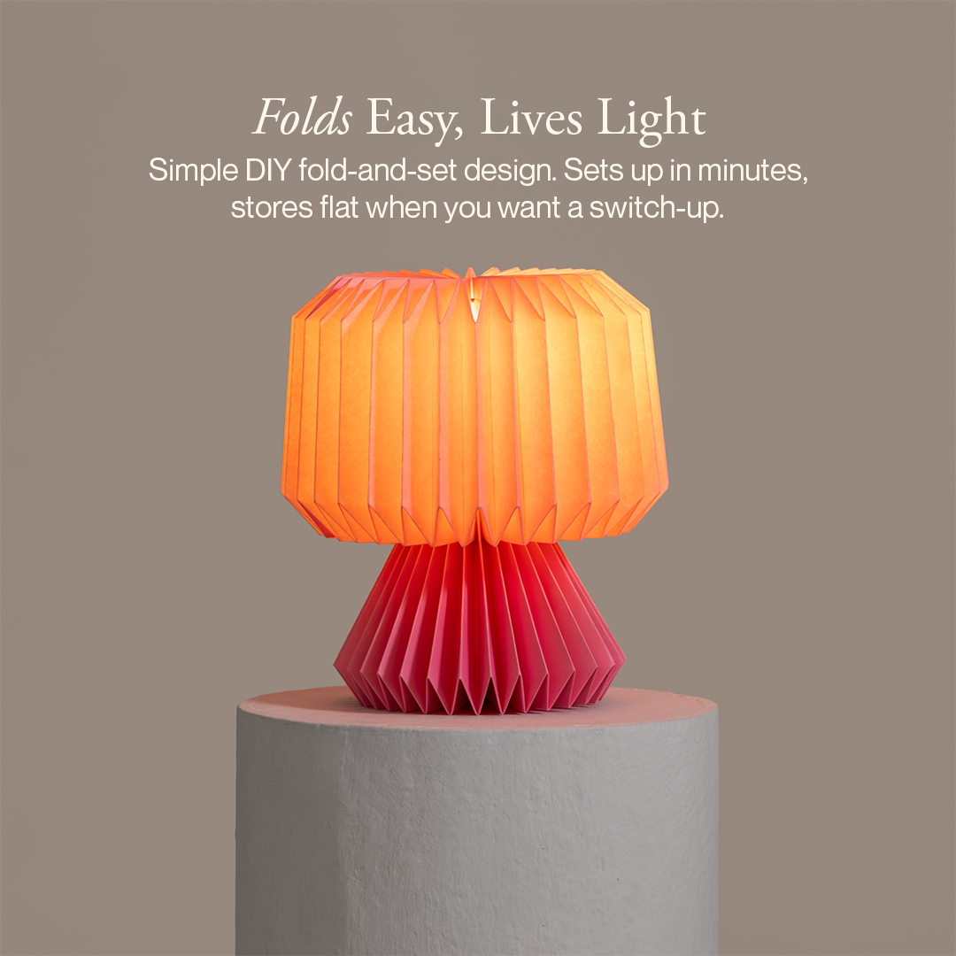 Orange and red lamp on a gray pedestal with text about its design on a brown background
