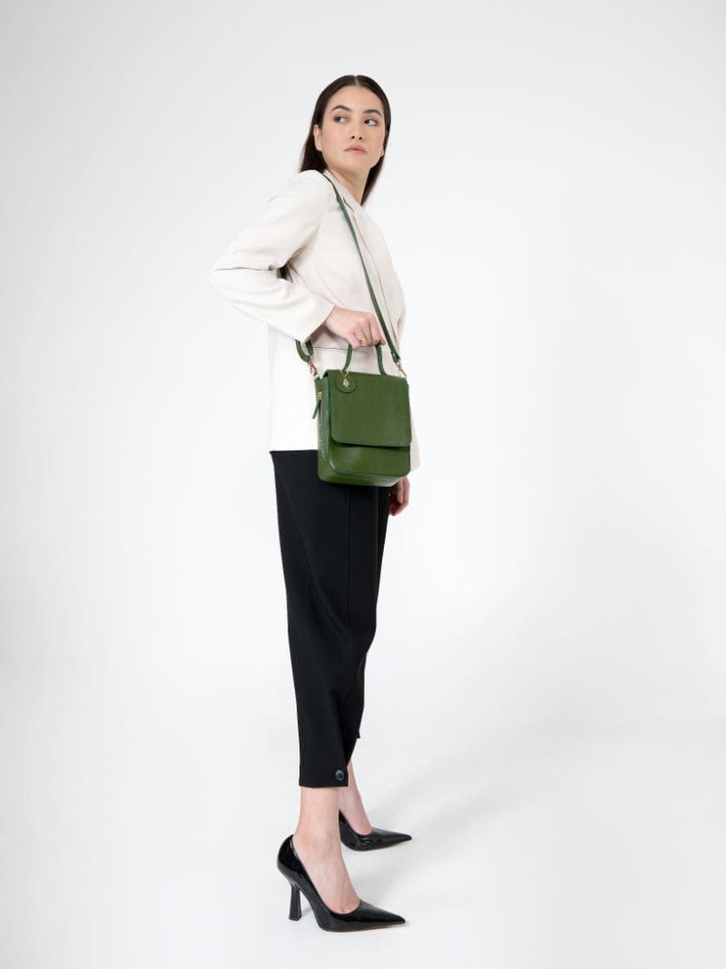 Model wearing Ceres green plant leather crossbody bag styled for everyday use with adjustable strap and structured design