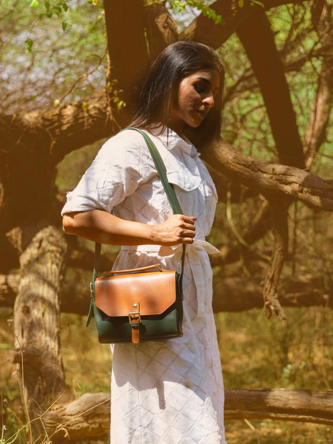 Model wearing Juniper Green plant leather sling bag crossbody outdoors showing everyday styling and functional design by Green Hermitage